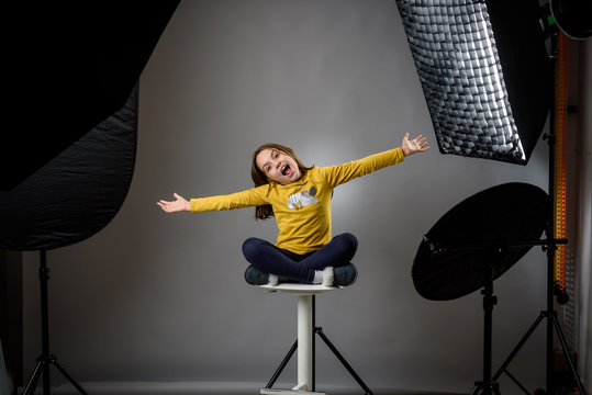 Photographing children in professional photo studio with lighting equipment.