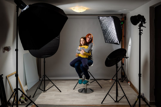 Photographing children in professional photo studio with lighting equipment.
