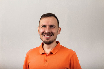 Portrait of a handsome smiling man in an orange shirt