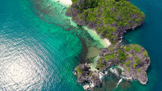 Rocky island with a white sandy beach. Caramoan Islands, Matukad , Philippines.