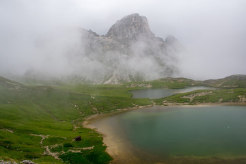 Lake Piano in the fog with amazing turquoise color of water. The mountain lake in the Dolomites. Italy