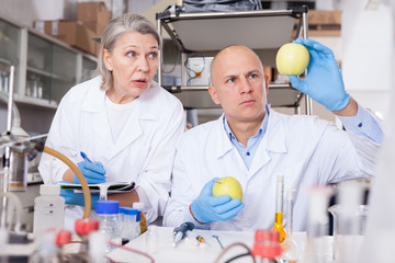 Scientists taking notes while performing experiments
