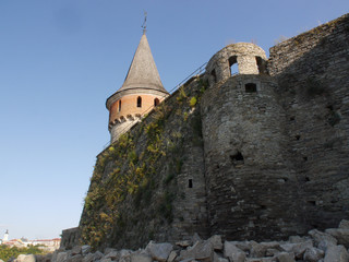 Fototapeta na wymiar Medieval castle in the city of Kamyanets-Podilsky, Ukraine . It is a formidable, strong fortress, whose walls are cut out of solid rock. The fortress stands at the top of a precipitous cliff . 