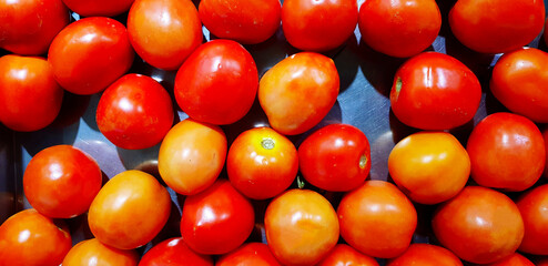 Many fresh tomato on stainless steel tray for sale at supermarket or market. Organic vegetable, Healthy food and Harvest of agriculture