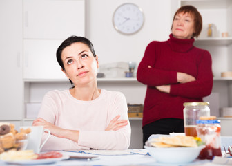 Mature female talking with young sad daughter