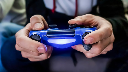 Male hands holding console controller, playing video game. One gamer person, close-up