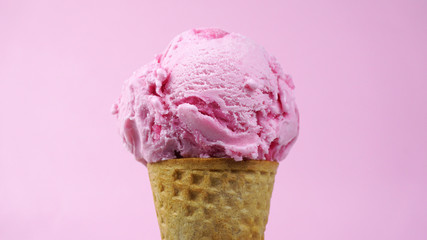 Ice cream flavoured Strawberry in waffle cone isolated on pink background, Closeup Front view Food concept.