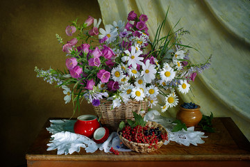 Still life with wildflowers in a basket, ripe berry