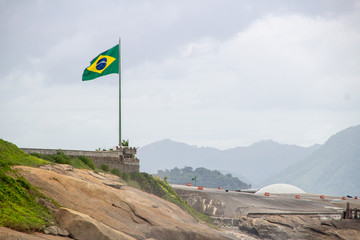 Brazilian flag on top of a rock in the Copacabana Fort in Rio de Janeiro.