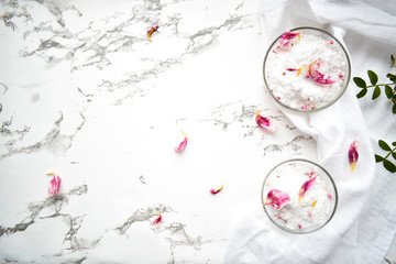 Set of cosmetics for women's skin and body care, sea salt on a gray marble background. Beauty blogger, concept of salon procedures. Flat lay, top view