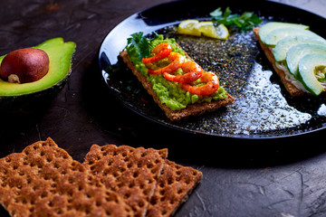 toasted bread with mashed avocado, olives, lemon and peeled fried shrimp