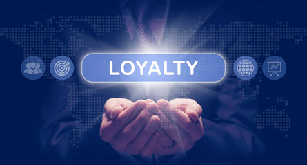 Businessmans cupped hands holding an Loyalty business concept on a computerised display.