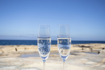 Beautiful photo composition of glasses of bubbly champagne drinks on the beach.
