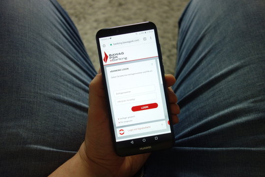 KONSKIE, POLAND - February 08, 2019: Man holding Huawei smartphone with BAWAG P.S.K. bank website displayed