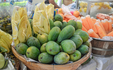 green mangoes on sale at street market in South east Asia