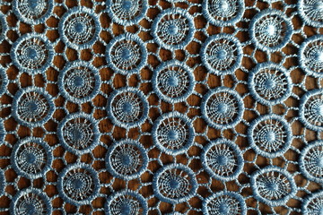 Sky blue crochet lacy fabric on wood from above