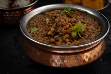Indian lentils simmered with tamarind and spices served in traditional bowl