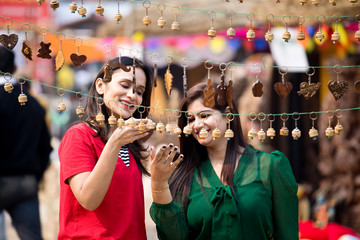 Two women shopping for necklace and earrings at street market