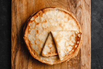 Maslenitsa Maslenitsa week is a holiday of food. A stack of Russian pancakes on a dark rustic wooden background. Front view with copy space
