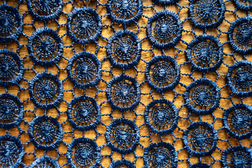 Surface of dark blue crochet lacy fabric on wood from above