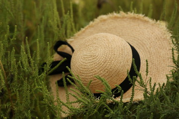  beige female straw hat lies on green grass, close-up
