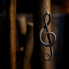 a metal sheet music key hangs in a rope in a blacksmith's workshop