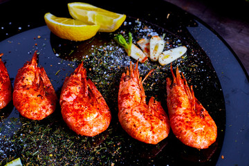 prawns fried with spices with sauce and lemon slices