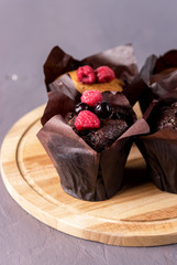 Tasty Chocolate Muffins Decorated with Berries on Old Wooden Tray Gray Background Dessert for Tea or Coffee Vertical