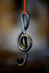 Obraz premium a metal sheet music key hangs in a rope in a blacksmith's workshop