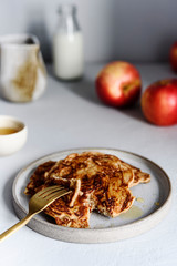 Homemade buckwheat apple pancakes with honey on light background. Pescajounes.  Hard light, deep shadow. Selective focus