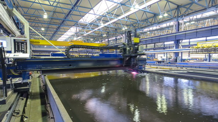 Naklejka premium Industrial Laser cutting processing manufacture technology of flat sheet metal steel material with sparks timelapse