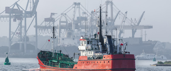 OIL PRODUCTS TANKER - The red ship sails to fuel terminal at  sea port