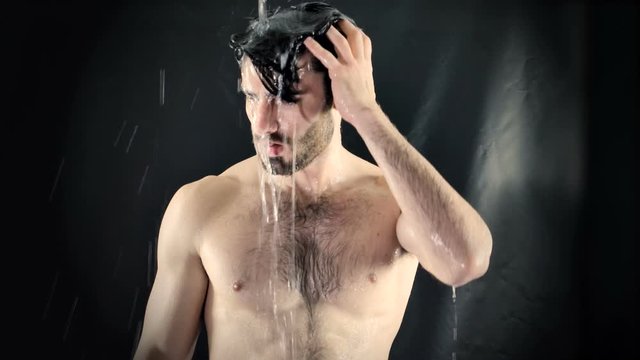 Young Bare Muscular Young Man Receiving Water Splashes in Studio