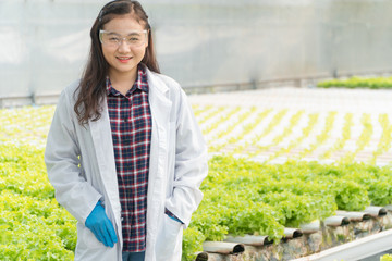 Agricultural Engineer standing and smiling in hydroponic Greenhouse farm after test plant system and measure growth for organic vegetables before harvest to market. Concept of agriculture technology