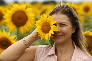  woman in a field with a sunflower, close-up, portrait