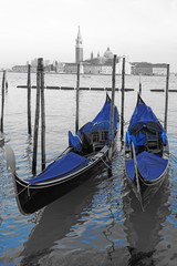 Fototapeta na wymiar Black and white and blue shot of gondola boats on the Grand Canal in Venice, Italy