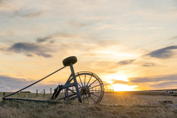 Old Haymaking Machine (tractor) on grass field sunset time