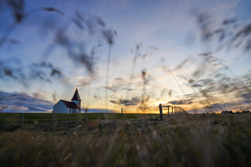 Beautiful woolden Church of Hellnar with grass field and sunset view at Snaefellsness, Vesturland, Iceland