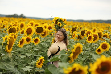 woman in a field with a bouquet of sunflowers, close-up, portrait