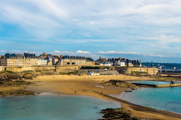 Saint Malo old town ramparts cityscape or skyline and Plage de Bon-Secours on a sunny day, Brittany, France. - obrazy, fototapety, plakaty
