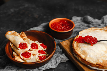 Maslenitsa Maslenitsa week is a holiday of food. Pancakes with red caviar on a wooden plate. The view from the top.  side view. space for text