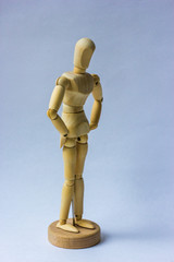 Wooden figure,isolated on white. Mannequin mused propping his sides with his hands on white background