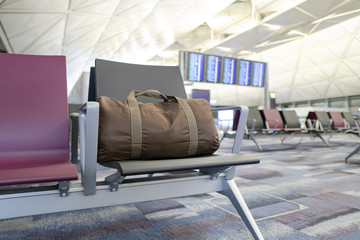 Brown backpack on seat at the interior of airport terminal.
