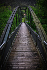 Fototapeta premium Puente de hierro en la montaña, sobre via de tren.