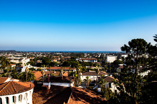 City of Santa Barbara, California viewed from above, view of the city's tiled roofs with the Pacific Ocean in the background, sunlight and summer day, horizontal image