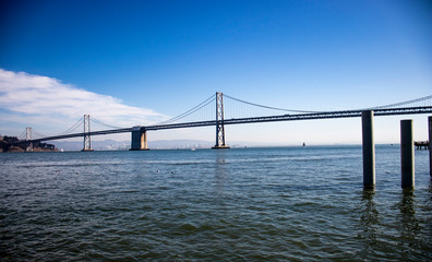 Fototapeta na wymiar Horizontal image of the metal bridge of San Francisco in California over the bay, summer blue sky, horizontal bridge