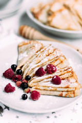 Pancakes with wild berries in a plate.Maslenitsa