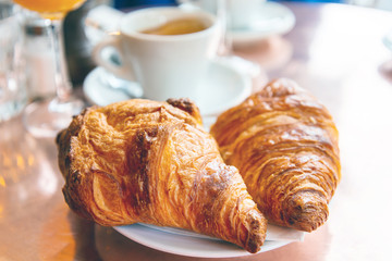 Breakfast with coffee and croissants on table