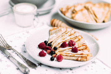 Pancakes with wild berries in a plate.Maslenitsa