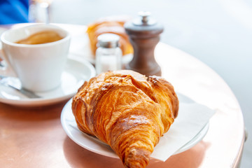 Breakfast with coffee and croissants on table